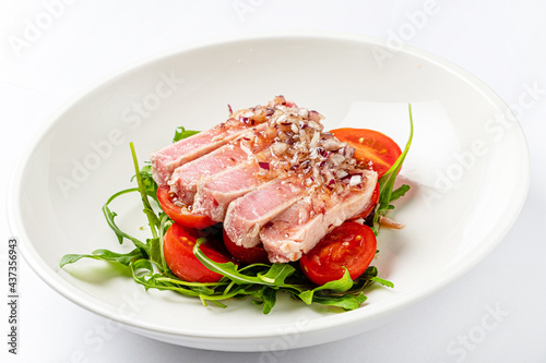 tuna fillet with salad on white plate