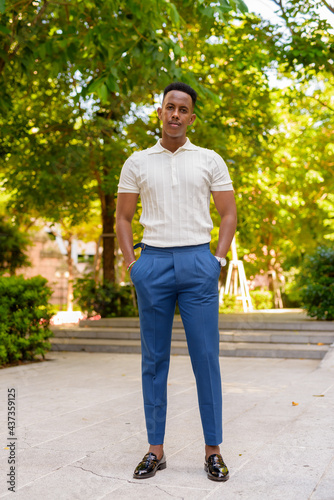 Full length shot of young African businessman outdoors in park