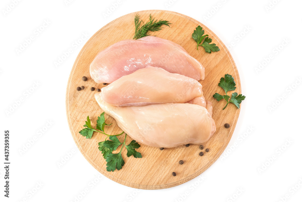 Raw chicken fillet on a round wooden board isolated on white. Raw chicken fillet on a round wooden board isolated on white.