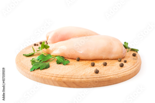Raw chicken fillet on round wooden board