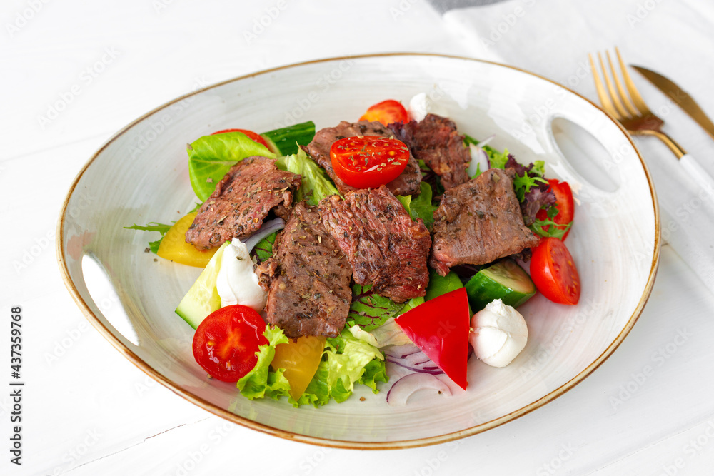 Fillet of beef with vegetable salad on wooden table