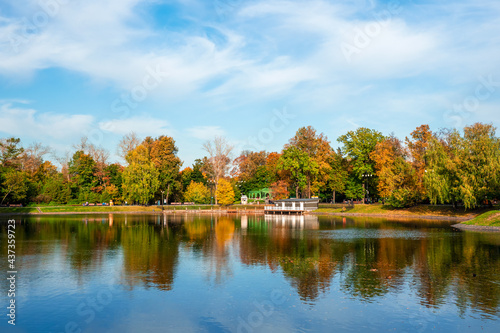 Beautiful Ostankino Park in Moscow, autumn pond with pier and reflection in the water
