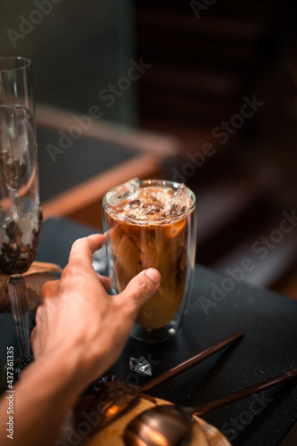 Close-up of iced coffee served on black table at cafe​