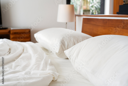 Bedroom and bedding sheets and pillow. Messy bed concept.White themed bed sheets and pillows messed up after nights sleep. copy space. Flat lay. Soft pillows on comfortable bed