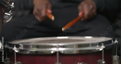 African man's hands hits the drum. Drummer performing solo with drumsticks. Percussion musical instrument.
