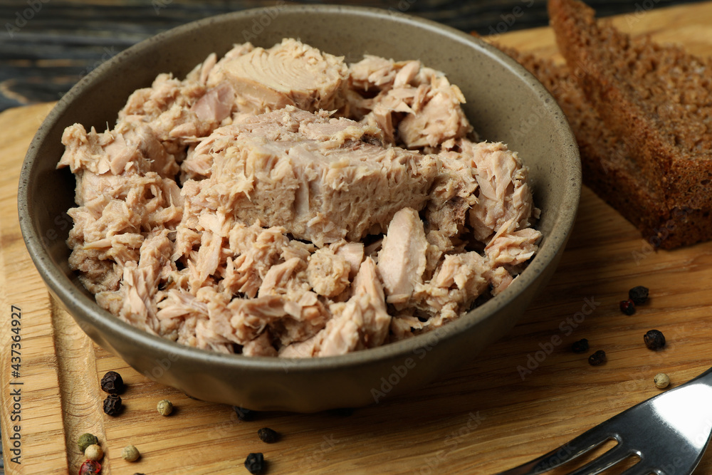 Board with plate of canned tuna on wooden background Board with plate of canned tuna on wooden background