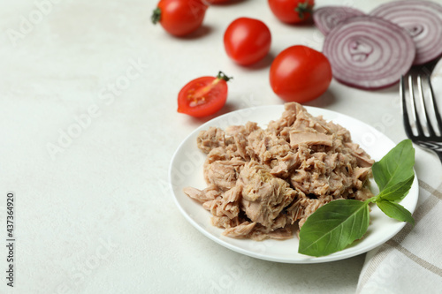 Concept of tasty eating with canned tuna on white textured background