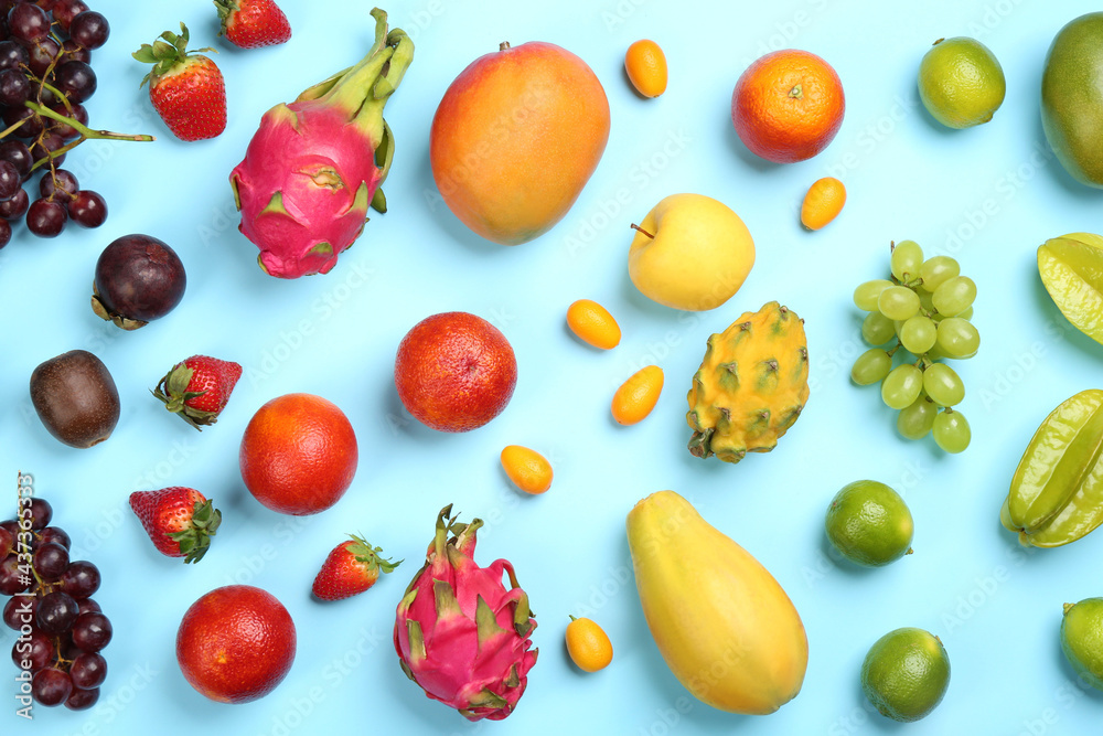 Many different delicious exotic fruits on light blue background, flat lay Many different delicious exotic fruits on light blue background, flat lay