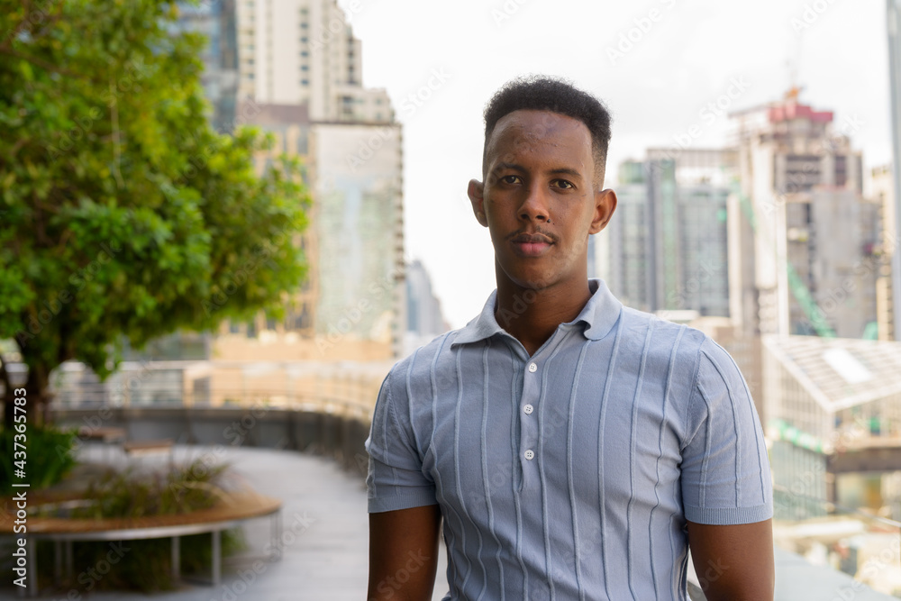 Portrait of young African businessman wearing casual clothes at rooftop garden