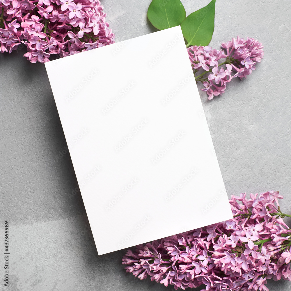 Greeting or invitation card mockup with purple lilac flowers on grey Greeting or invitation card mockup with purple lilac flowers on grey