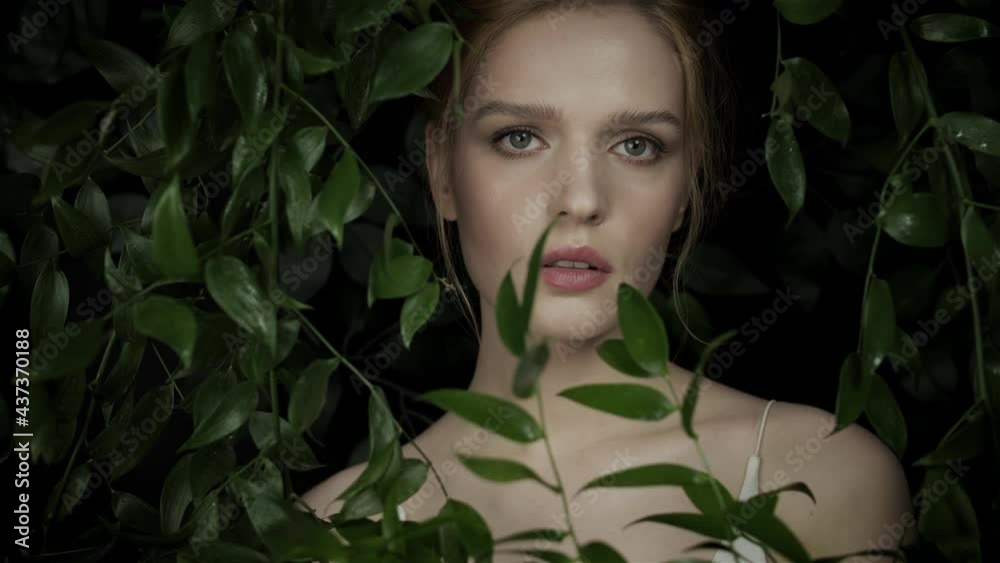 Woman among exotic plants on dark tropics. Natural makeup. Facial clean skin. Advertising of natural and organic cosmetics. Spa treatments. The girl in the dark dense thickets. Woman among exotic plants on dark tropics. Natural makeup. Facial clean skin. Advertising of natural and organic cosmetics. Spa treatments. The girl in the dark dense thickets.