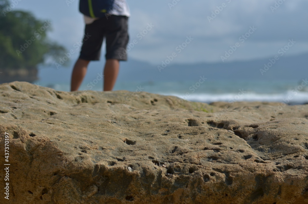 beach rocks with blurred man standing heading ocean beach rocks with blurred man standing heading ocean