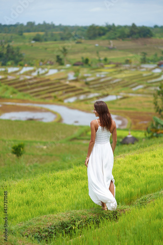 Young woman turning her back posing against the background of rice fields