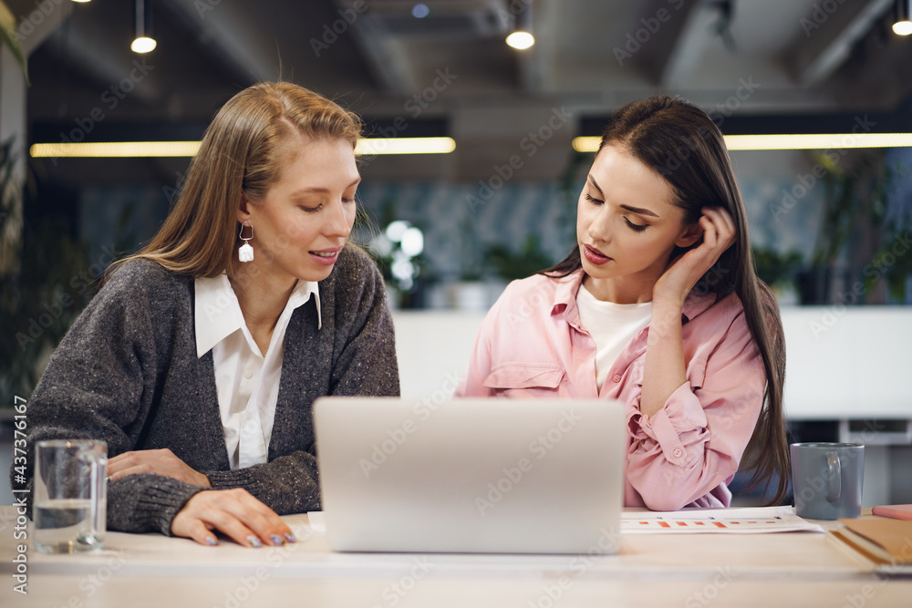 Two young women working together in office Two young women working together in office