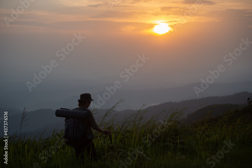 Silhouette of woman traveller is relaxing with hiking and camping in holiday. On the top of mountain during sunset.The concept lifestyle of nature.