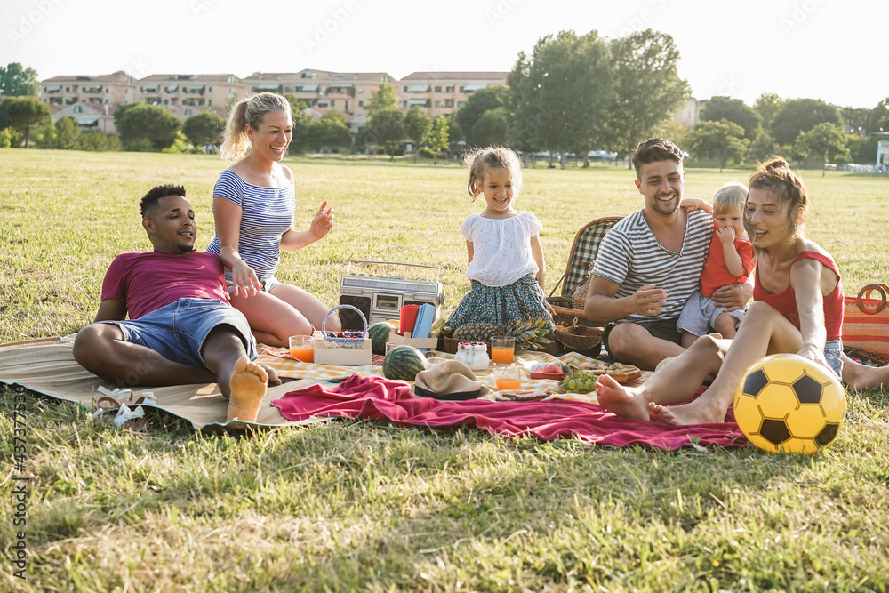 Φωτογραφία Happy multiracial families having fun doing picnic outdoor in city park - Main f