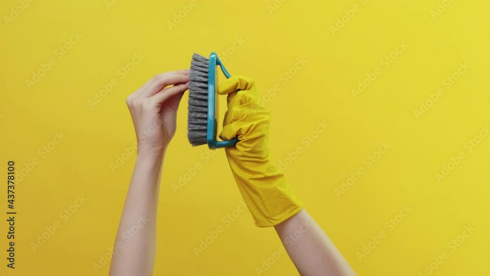 Hygiene tools. Cleaning game. Socks theater. Washing equipment. Female hands one protective gloves washing nails perfect manicure blue handle brush isolated yellow copy space. Hygiene tools. Cleaning game. Socks theater. Washing equipment. Female hands one protective gloves washing nails perfect manicure blue handle brush isolated yellow copy space.