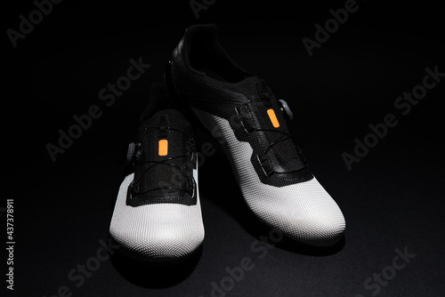 A pair of competition cycling shoes on black background. Special footwear for bicycle. © Egoitz