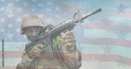 Composition of male soldier holding machine gun over american flag