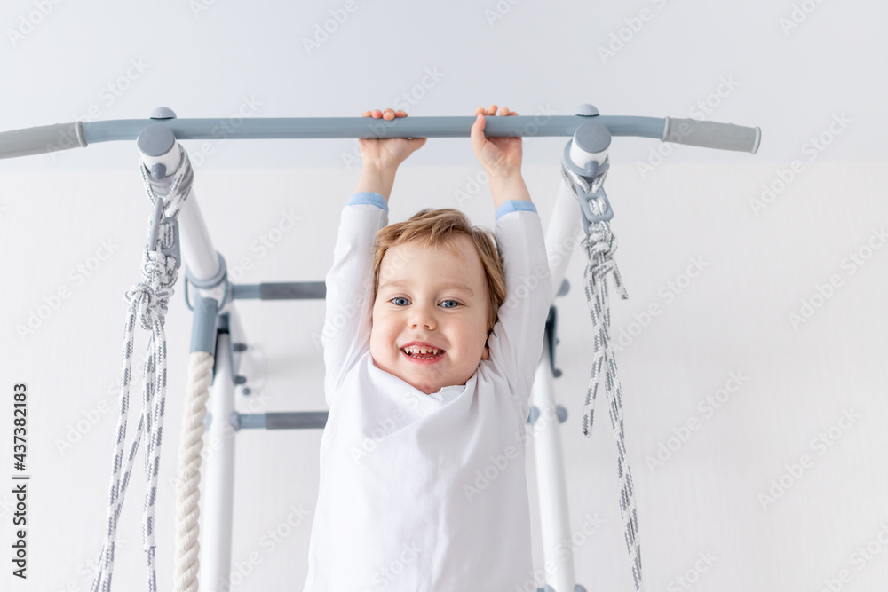 Fototapeta premium a child a boy climbs on the Swedish wall of the house