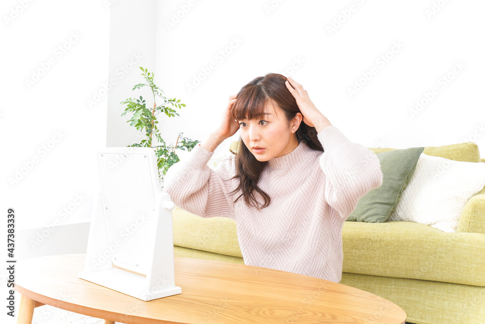 髪の毛のケアをする若い女性 髪の毛のケアをする若い女性