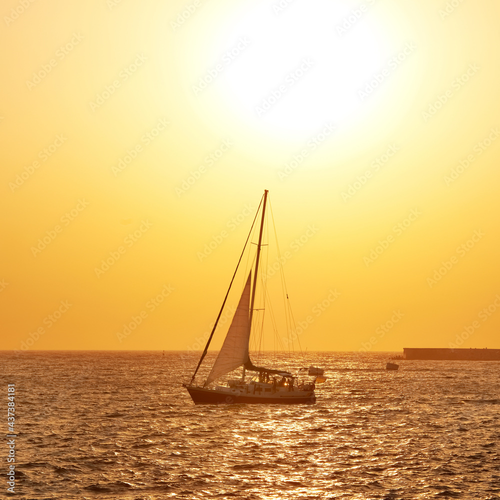 Fototapeta premium Sail boat against sea sunset