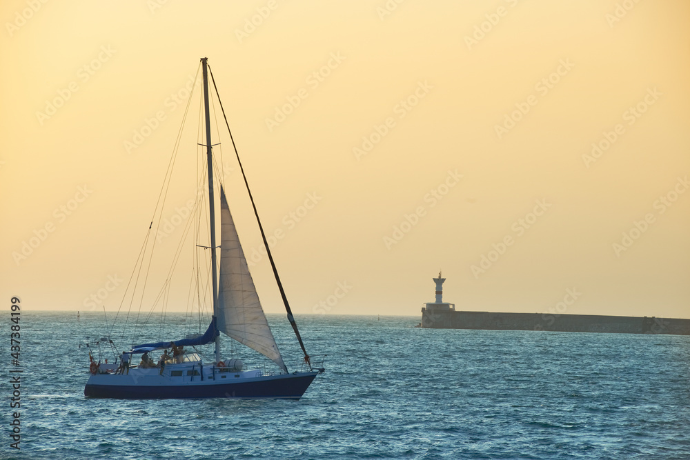 Sail boat against sea sunset