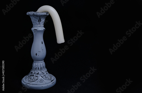 Candle Holder with a Drooping Candle on a black Background Concept Impotence and Old Age in Sex