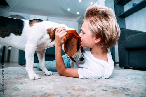 Photography Kid playing with dog at home - Child kissing pet friend in the living room - Peo