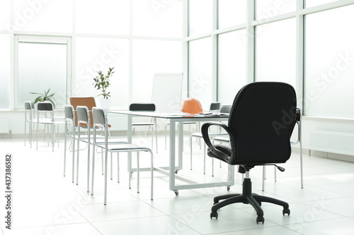Flipchart construction helmet chairs glass table in office space