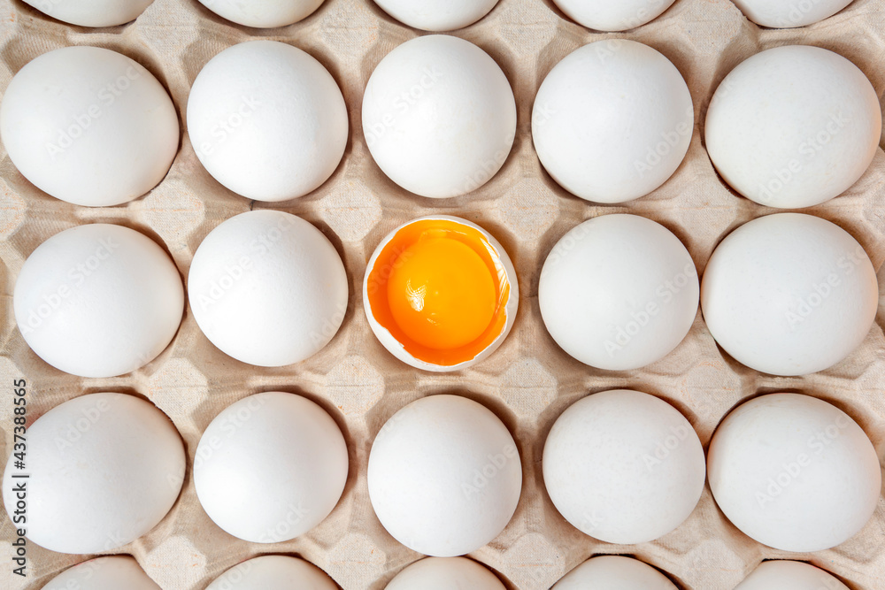 White eggs with one broken egg in carton box. Eggs background. Food concept. Flat lay, top view. White eggs with one broken egg in carton box. Eggs background. Food concept. Flat lay, top view.