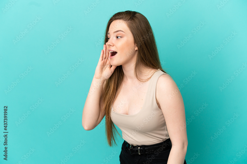 Teenager girl over isolated blue background shouting with mouth wide open to the side Teenager girl over isolated blue background shouting with mouth wide open to the side