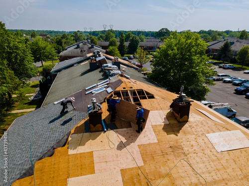 Roof shingles need with new shingles of an apartment building replacing gray asphalt tile photo