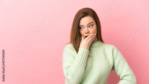 Teenager girl over isolated pink background doing surprise gesture while looking to the side