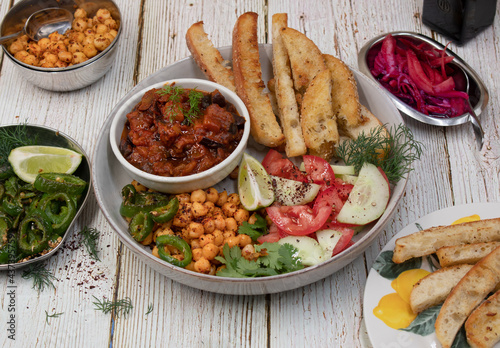 Vegan Middle Eastern bowl consisting of eggplant dip, spicy chickpeas, pita slices and salad