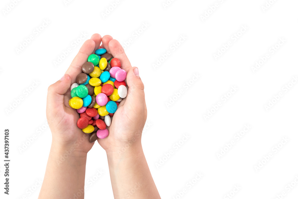 round colored candies in children's hands isolated on a white background. Copy space.