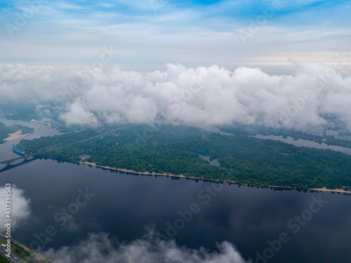 High view of the Dnieper River in Kiev through the clouds. Spring cloudy morning. Aerial high view. © Sergey