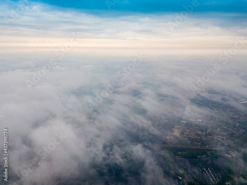High flight above the clouds in Kiev. Spring cloudy morning. Aerial high view.