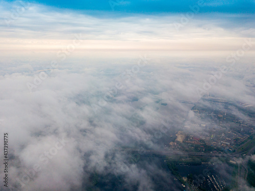 High flight above the clouds in Kiev. Spring cloudy morning. Aerial high view.