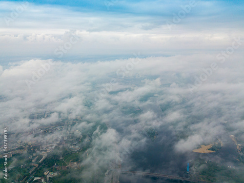 High flight above the clouds in Kiev. Spring cloudy morning. Aerial high view.