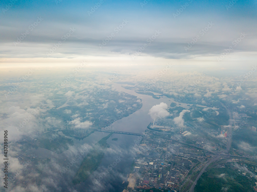 High flight above the clouds in Kiev. Spring cloudy morning. Aerial high view.