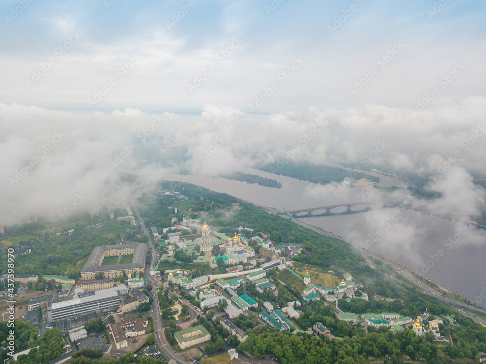 High view of the Dnieper River in Kiev through the clouds. Spring cloudy morning. Aerial high view. High view of the Dnieper River in Kiev through the clouds. Spring cloudy morning. Aerial high view.