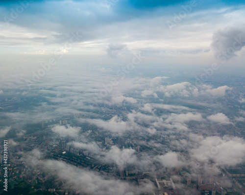 High flight above the clouds in Kiev. Spring cloudy morning. Aerial high view.