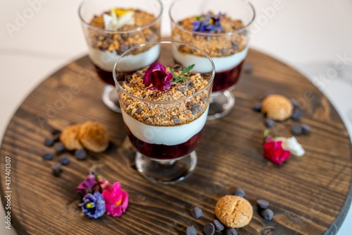 Beautifully decorated desserts in clear glasses on a wooden board
