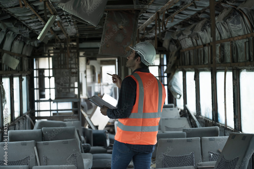 Fototapeta premium man in a train. Workers are checking for damage for renovation train passenger containers. 