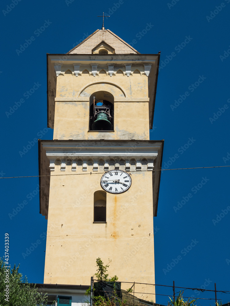 Old tower church with clock and bell in Cinque Terre National Park in Italy on city hill.