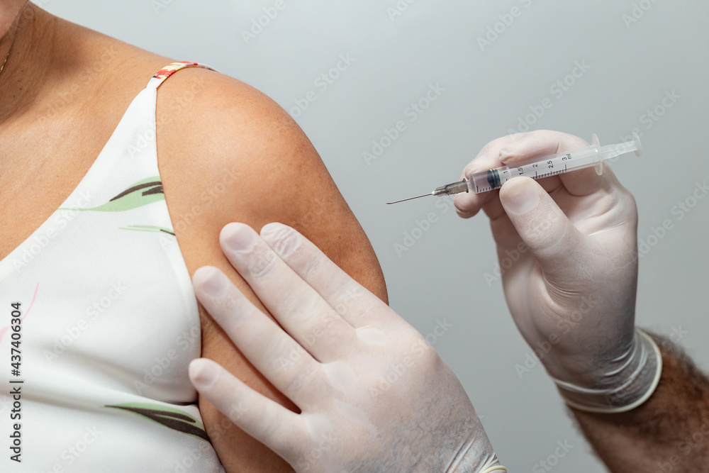 Mãos de médico ou enfermeiro aplicando vacina no braço de paciente ...