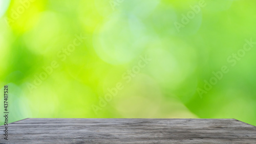 Abstract bokeh sunlight and tree background of nature in green color with Steel black table. 