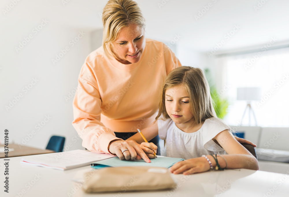 Mom helping kid with homework at home Mom helping kid with homework at home