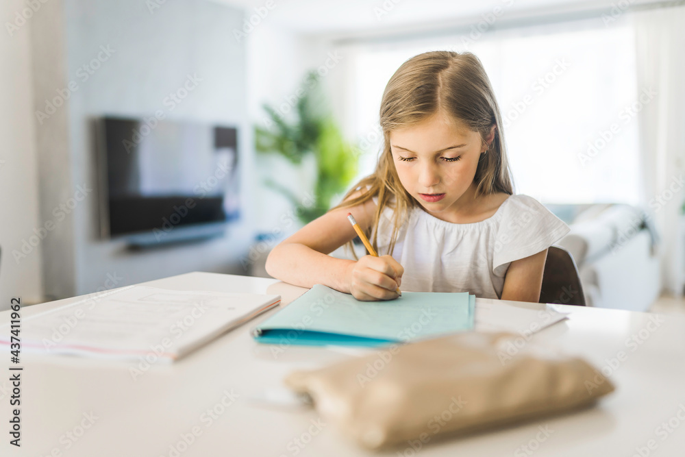 Pretty little girl enjoys learning and doing some homework Pretty little girl enjoys learning and doing some homework